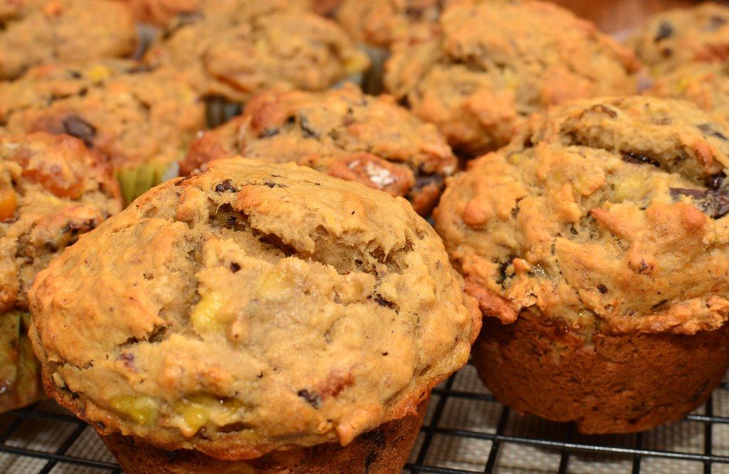 Muffins studded with dried fruit, cooling on a rack
