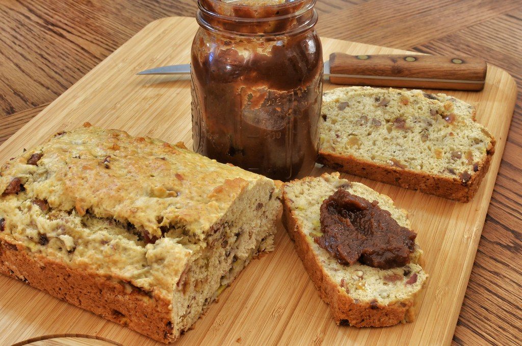 A nut loaf on a board, part of it sliced