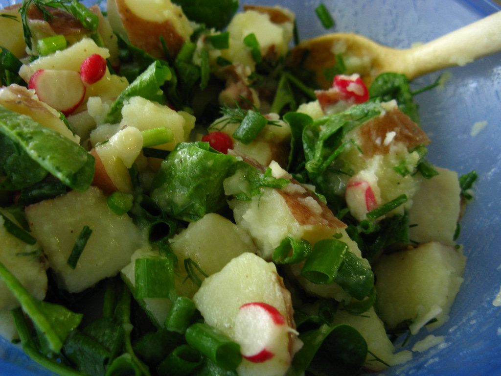 A bowl of potato salad with green onion