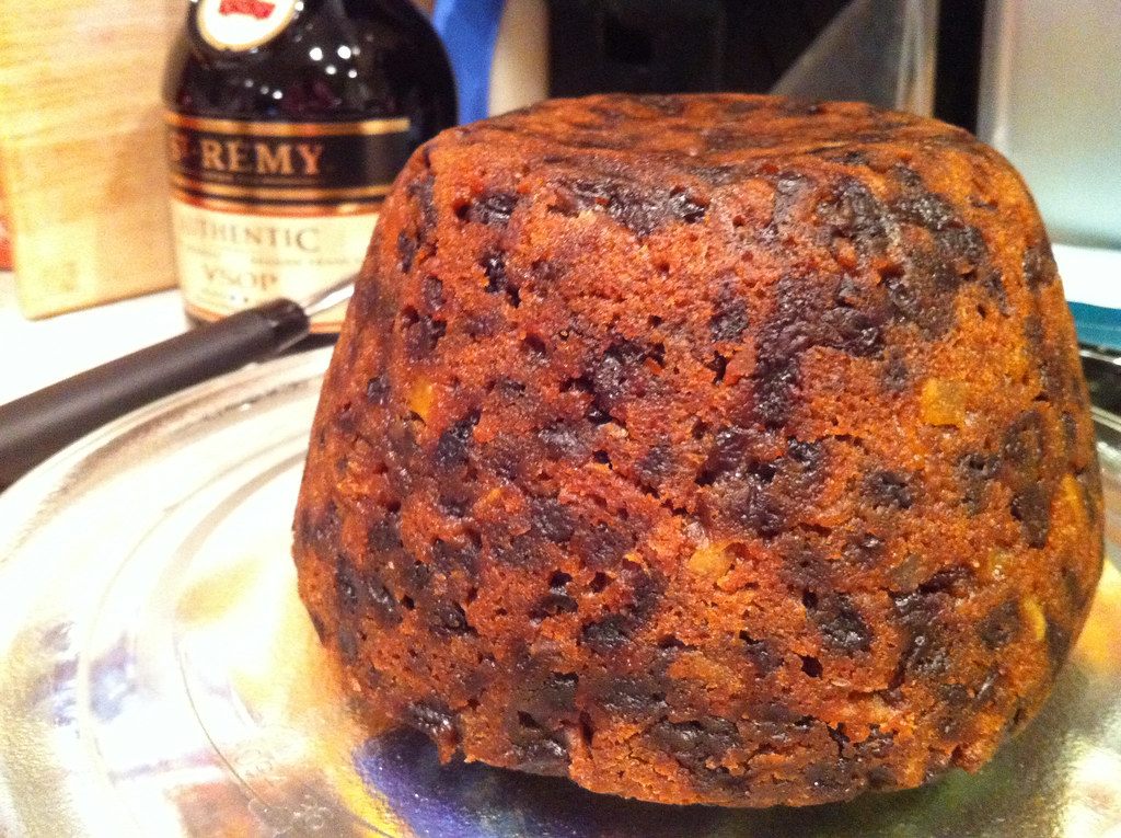 A dark steamed Christmas pudding turned out of its bowl