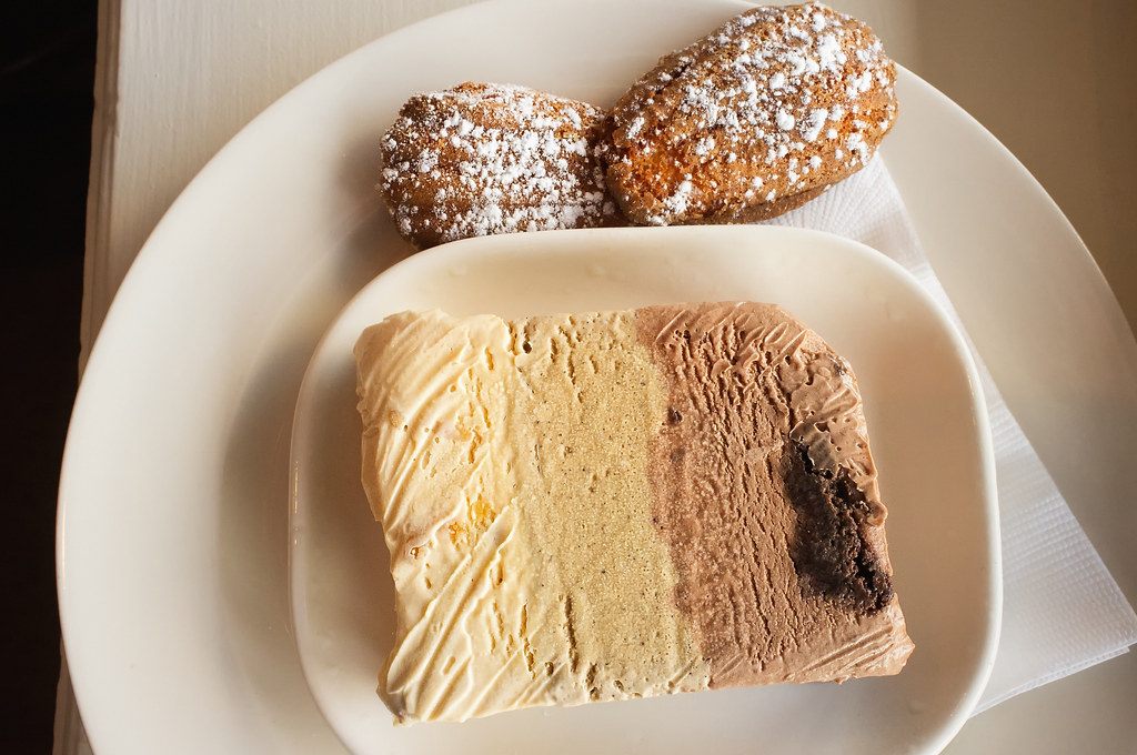 A slice of layered cream dessert on a white plate
